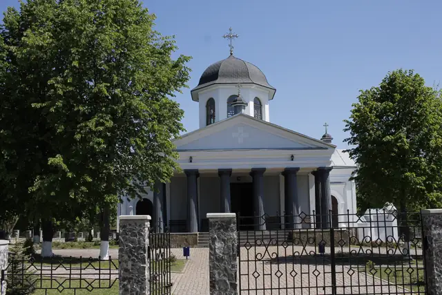 Свято-Хрестовоздвиженська церква в Розумівці: білий класицистичний об’єм із колонним портиком і темною банею на восьмерику
