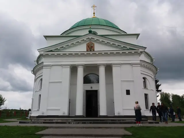Миколаївська церква в Диканьці: біла класицистична споруда з колонним портиком і зеленою банею