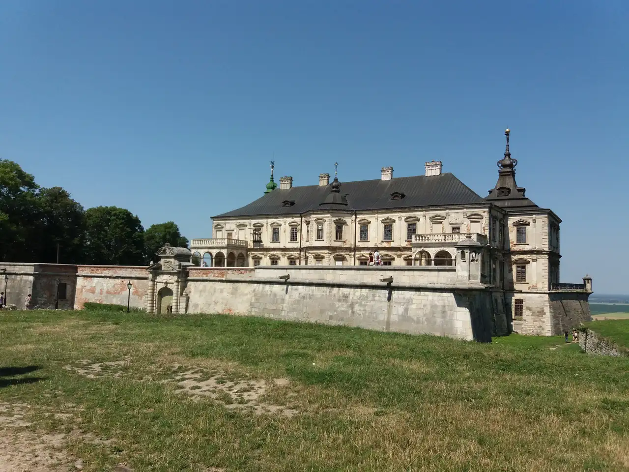 Видовжений фасад Підгорецького замку з баштою над кам'яними бастіонними мурами