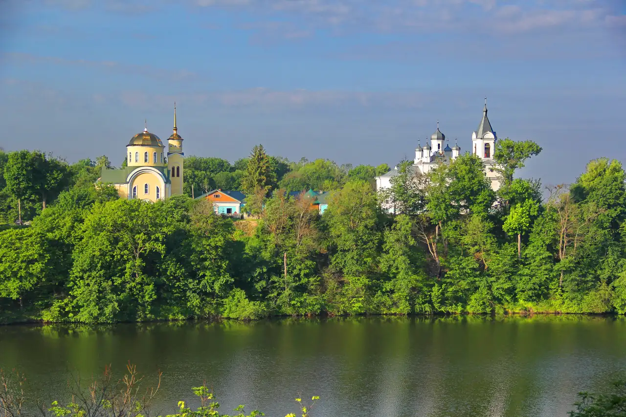 Тригірський монастир на високому лісистому березі Тетерева, вигляд із протилежного берега