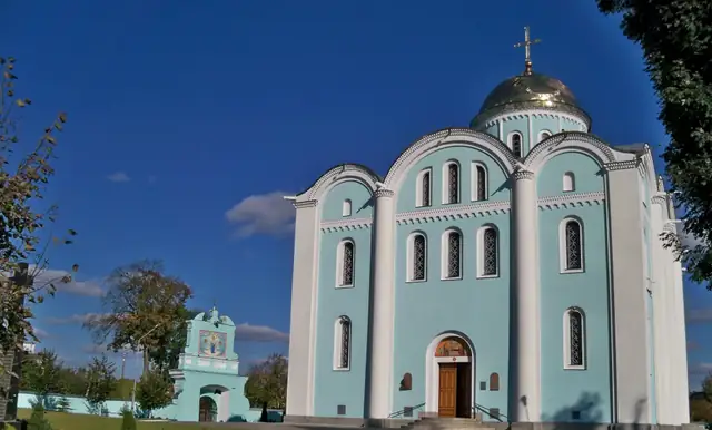 Успенський собор у Володимирі: блакитний мурований храм із золоченою банею й нижча надбрамна споруда ліворуч